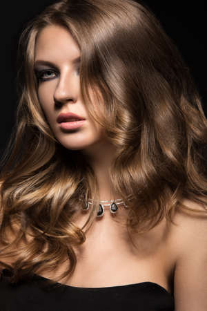 Beautiful woman with evening make-up and long straight hair . Smoky eyes. Fashion photo. Picture taken in the studio on a black background.の写真素材