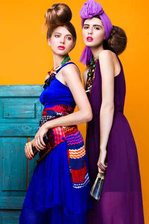 Beautiful fashionable women an unusual hairstyle in bright clothes and colorful accessories. Cuban style. Picture taken in the studio on a bright background.の写真素材