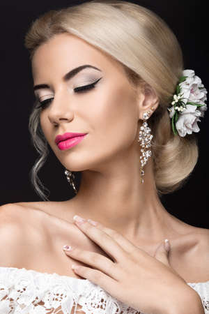 Portrait of a beautiful blond woman in the image of the bride with flowers in her hair. Picture...
