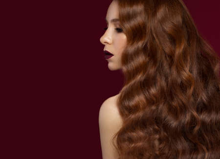 Beautiful Redhead girl with a perfectly curls hair and classic make-up. Beauty face. Picture taken...