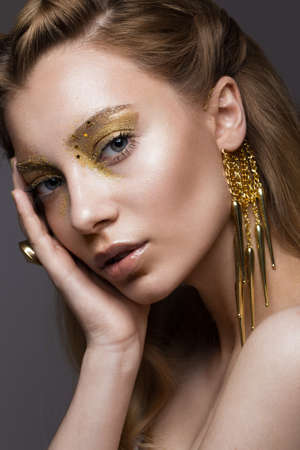 Beautiful girl in Underwear with creative gold makeup and hair. The beauty of the face. Photos shot in the studio.の写真素材