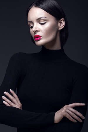 Beautiful brunette girl in a black dress, straight hair and trendy makeup. Glamour beauty face. Photos shot in the studio.の写真素材
