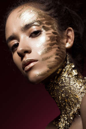 Beautyful girl with gold glitter on her face.Art image beauty face. Picture taken in the studio.の写真素材
