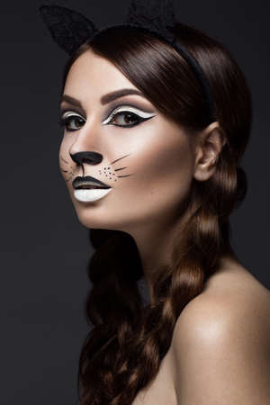 Beautiful girl in the image of a cat with art make-up and lace ears. beauty face. Photos shot in the studio.の写真素材