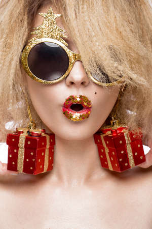 Jolly cheerful beautiful girl in a New Year's image with a festive make-up with a smile. The beauty of the face. Photos shot in the studio.の写真素材