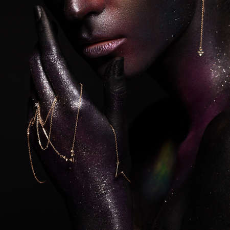 Beautiful girl with art space makeup on her face and body. Glitter Face. Photo taken in the studio.の写真素材
