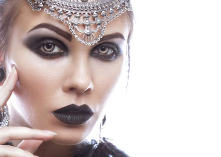 Beautiful girl in style of black queen. Image for a Halloween. Photos shot in the studio on a white background.の写真素材