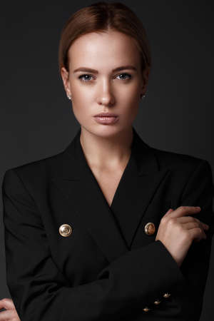sexy fashion model with long hair, young European attractive, beautiful eyes, perfect skin is posing in studio for glamour vogue test photo shoot showing different poses. Picture taken in the studio on a gray background.の写真素材