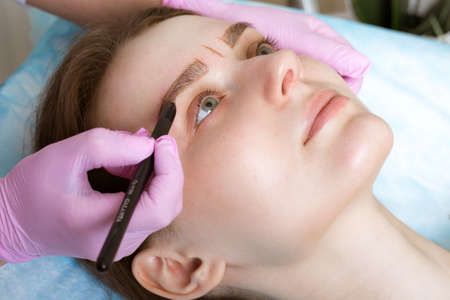 Permanent microblasting tattooing freckles to a woman in a beauty salon.