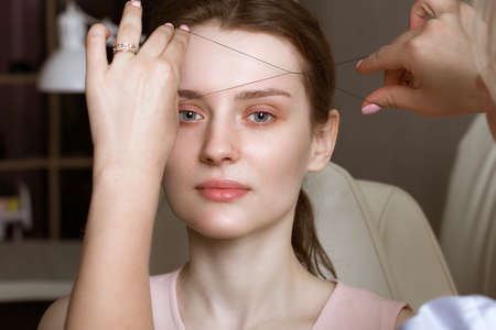 Permanent microblasting tattooing freckles to a woman in a beauty salon.