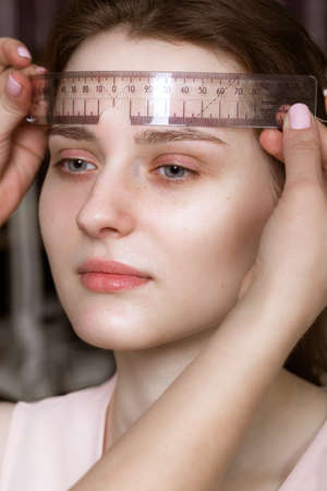 Permanent microblasting tattooing freckles to a woman in a beauty salon.