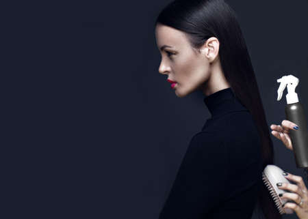Beautiful brunette girl in a black dress, straight hair and trendy makeup. Glamour beauty face. Photos shot in the studio.の写真素材