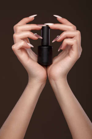 Beautiful classic manicure on female hand with nail polish. Close-up. Picture taken in the studioの写真素材
