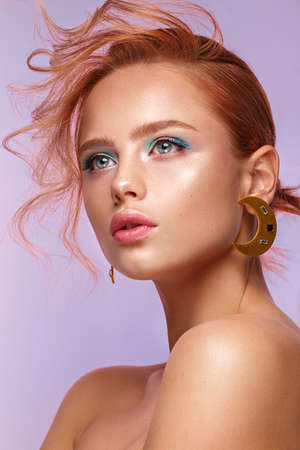 Beautiful girl with unusual accessories and make-up on a bright background. Beauty face. Photo taken...