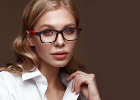 Beautiful girl in stylish clothes with glasses for vision and red sexy lips. Beauty face. Photo...