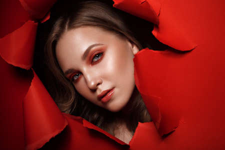 Beautiful fresh girl with perfect skin, bright red make-up. Beauty face. Photo taken in the studio.