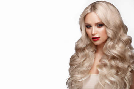 Beautiful blonde in a Hollywood manner with curls, natural makeup and red lips.. Beauty face and hair. Picture taken in the studioの写真素材