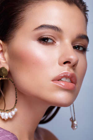 Beautiful fresh girl with classic make-up, smooth hair in a purple dress. Beauty face. Photo taken...