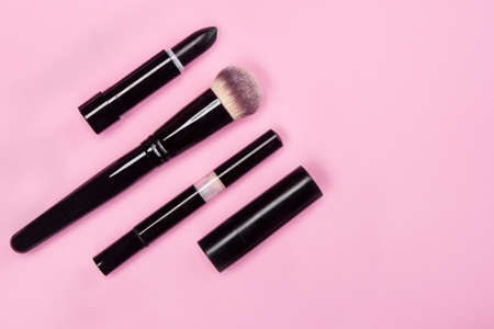 Set of brushes and cosmetic products on a pink background.の写真素材