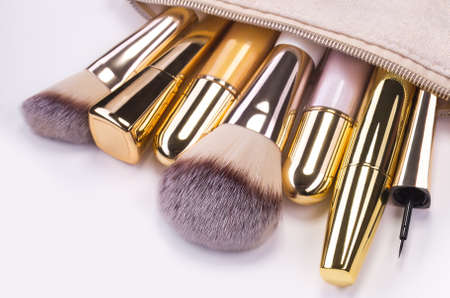 Set of brushes and cosmetic products in a cosmetic bag on a white background.の写真素材