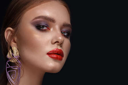 Beautiful girl with bright fashionable make-up and unusual purple accessories. Beauty face. Photo...