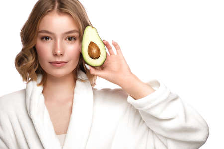Beautiful tender young girl in a white coat with clean fresh skin posing in front of the camera....