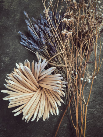 Wooden sticks, a tool for manicure on a background of flowers. Nail salon.の写真素材