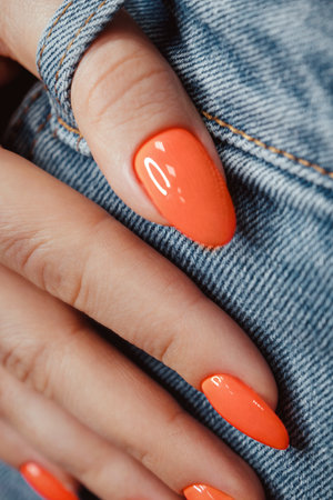 Bright neon manicure on female hands on the background of jeans. Nail design.の写真素材