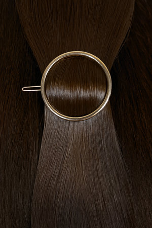 A strand of natural hair extensions with a hairpin.の写真素材