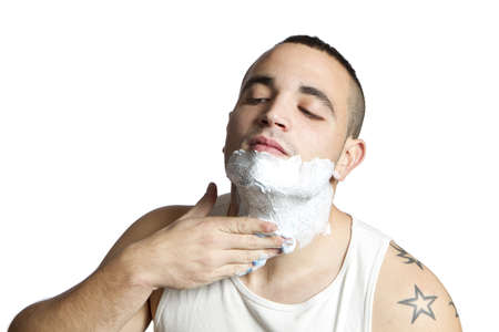 young man giving himself shaving cream on white backgroundの写真素材