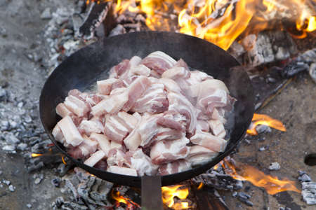 saucepan of bacon frying in fireの写真素材