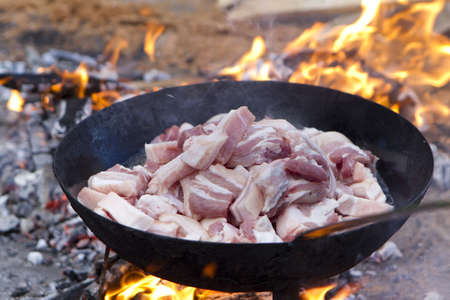 saucepan of bacon frying in fireの写真素材