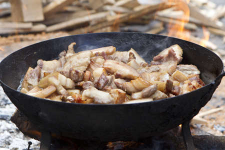 saucepan of bacon frying in fireの写真素材