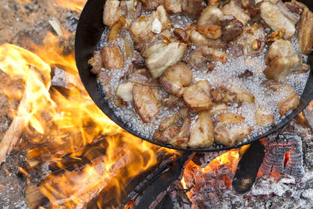 saucepan of bacon frying in fireの写真素材