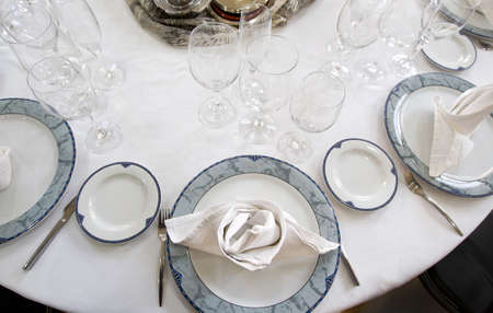 table mounted circular restaurant with covered dishes and glasssの写真素材