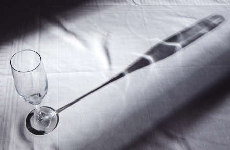 glass of champagne on a tablecloth with shadowの写真素材
