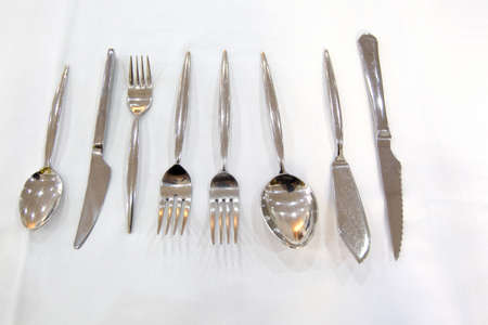 flatware set on restaurant table with knives, forks and spoonsの写真素材
