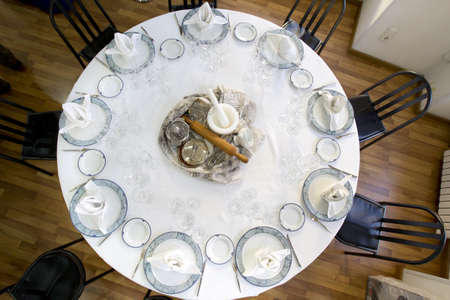 table mounted circular restaurant with covered dishes and glasssの写真素材