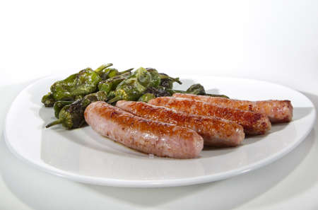 plate of sausages and roasted green peppersの写真素材