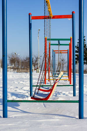 winter scene with couple of swings in parkの写真素材