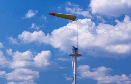 Airsock with signal mast on blue skyの写真素材