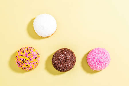 Marshmallow biscuits with colored sugar sprinkles over yellow backgroundの写真素材