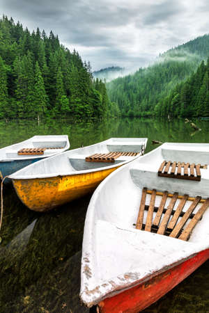 Mountain lake boats on cloudy dayの写真素材