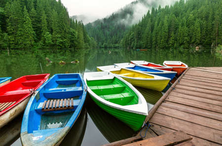 Colorful boats moored on a mountain lakeの写真素材