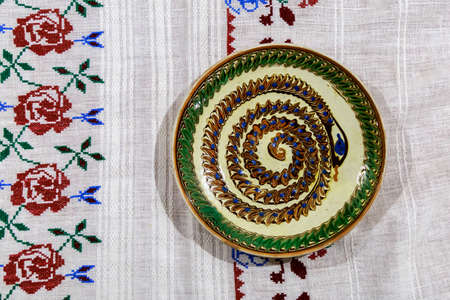 Hand embroidered tablecloth with decorative ceramic plate.Decorative ceramic plateの写真素材