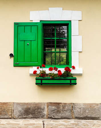 Green window with flower box and shuttersの写真素材