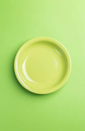 Green plate on green background above view.Useful as a food backgroundの写真素材