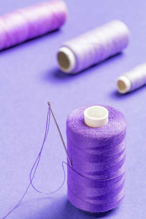 Purple thread bobbin and needle.Useful as tailor backgroundの写真素材