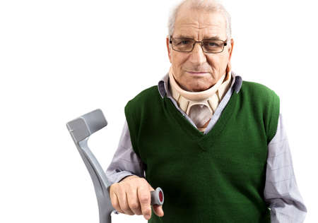 Old man with a surgical cervical collar supporting in a walking stick on white backgroundの写真素材