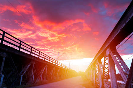 Sunrise with spectacular sky over an old iron bridge.